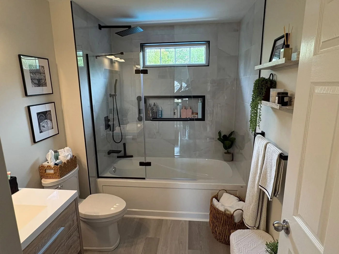 Custom tiled tub and shower install with a glass panel and matte black fixtures